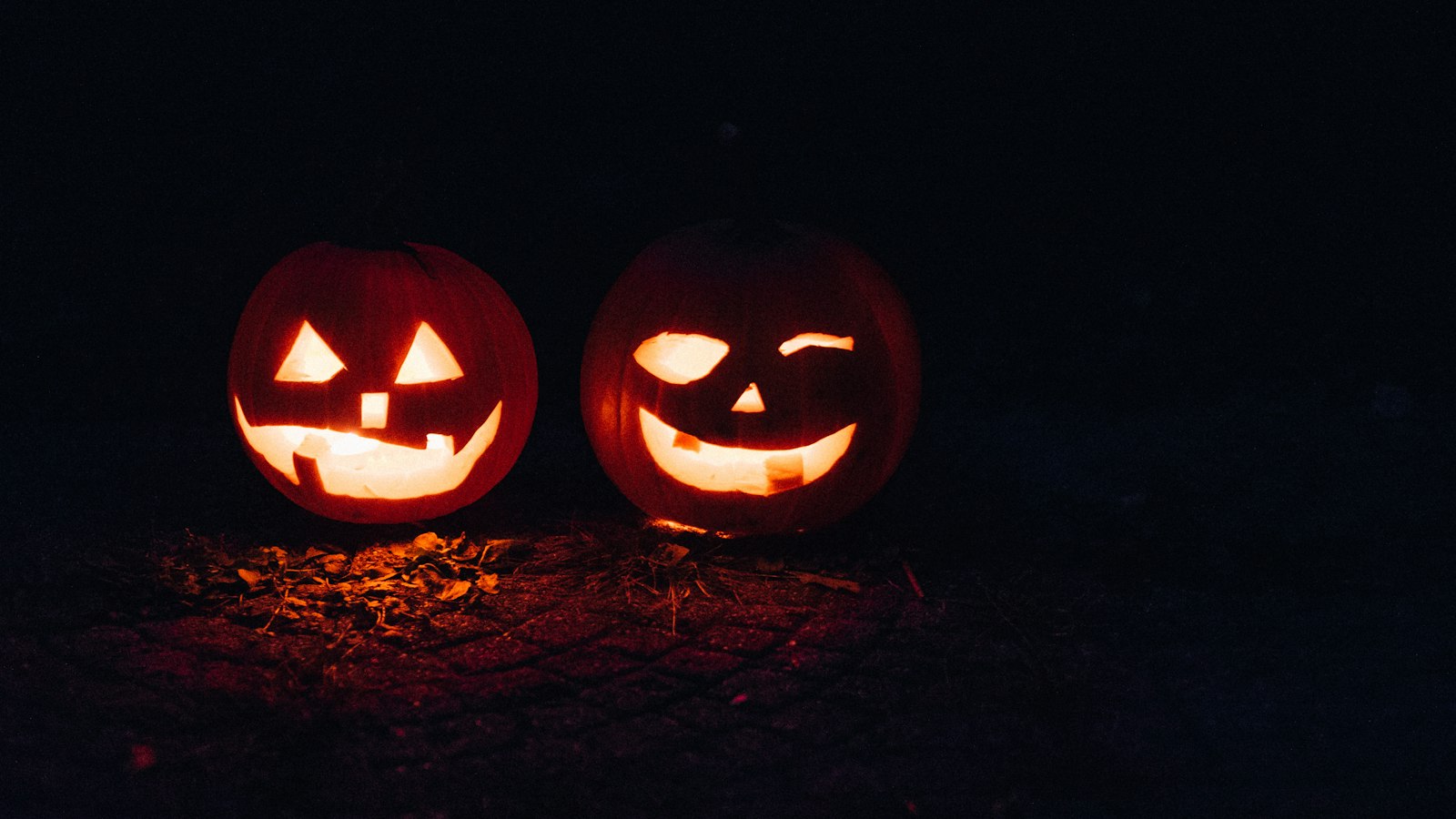 Deux citrouilles d’Halloween sculptées et allumées dans la nuit