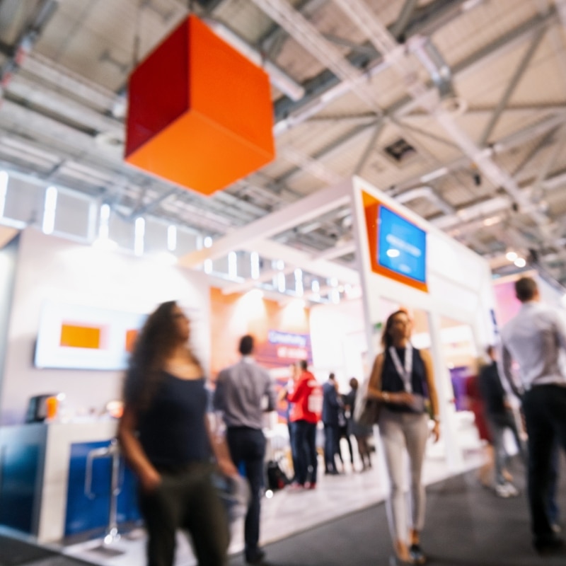 Visiteurs parcourant les allées d'un salon professionnel entre les stands